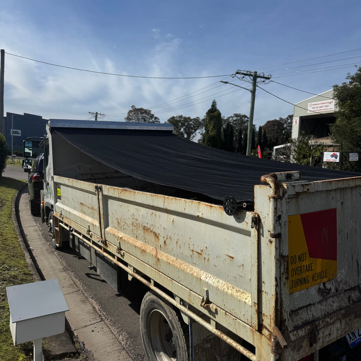 Australian-made black mesh tarp on a spring-loaded pull tarp unit
