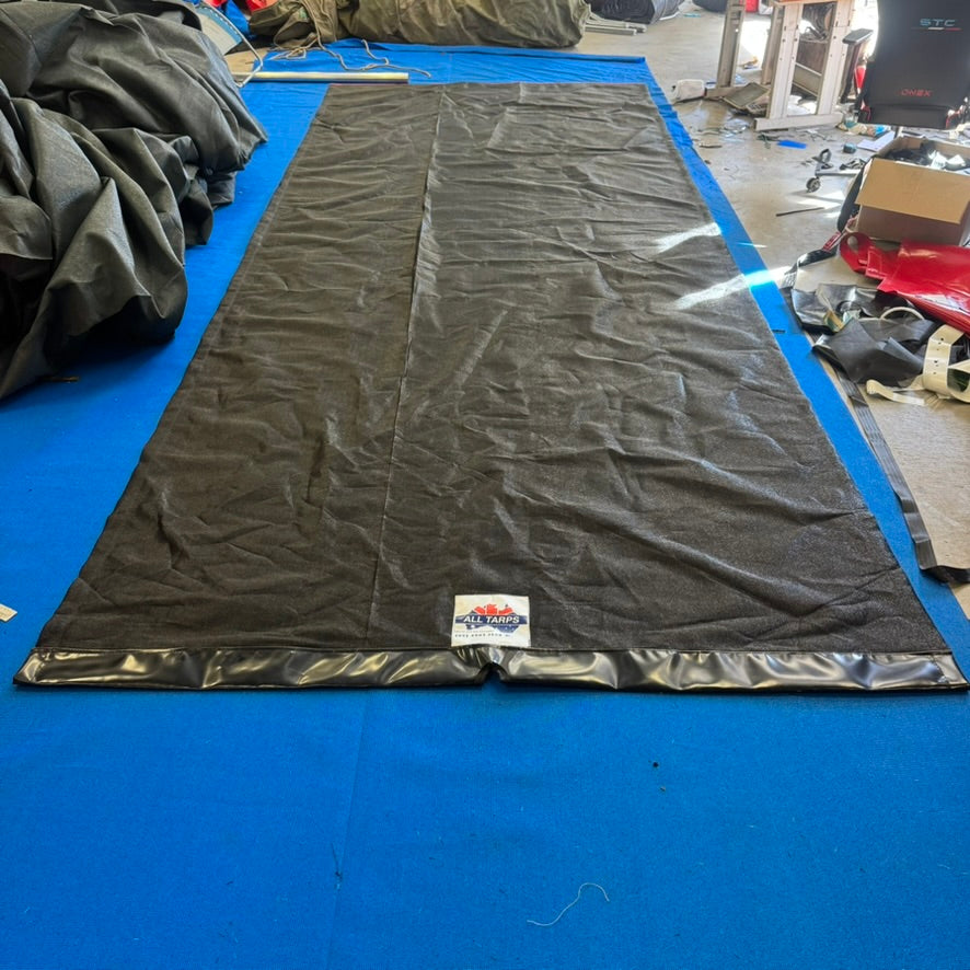 Black mesh tarp fitted to a retractable pull tarp system