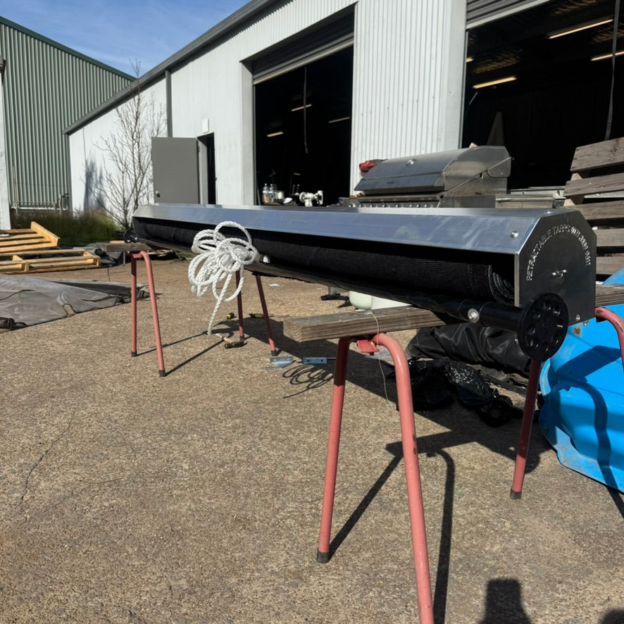 Retractable pull tarp setup with black mesh tarp cover