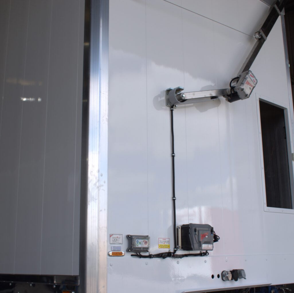 White trailer with electrical components on a dark background